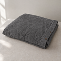 Stonewashed linen duvet cover in Charcoal, folded with coconut-shell buttons