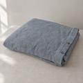 Stonewashed linen duvet cover in Dusk, folded with coconut-shell buttons